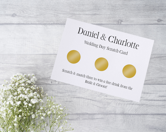 A close-up view of a beautifully designed scratch card with elegant typography and decorative elements. The scratch card features customised names and a wedding date, surrounded by symbols representing hidden prizes.