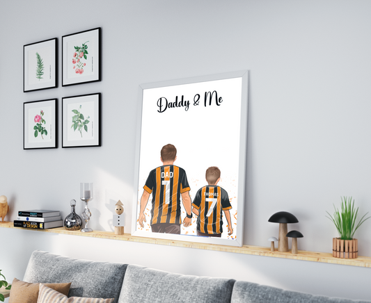 Personalised Father's Day picture featuring a father and child wearing their favorite football shirts. The child is happily perched on the father's shoulders. The football shirts display custom names and numbers, adding a personal touch to the picture. The vibrant colors and attention to detail highlight the love and bond between the father and child, as well as their shared passion for football. This heartwarming picture captures a special moment that will be treasured for years to come.