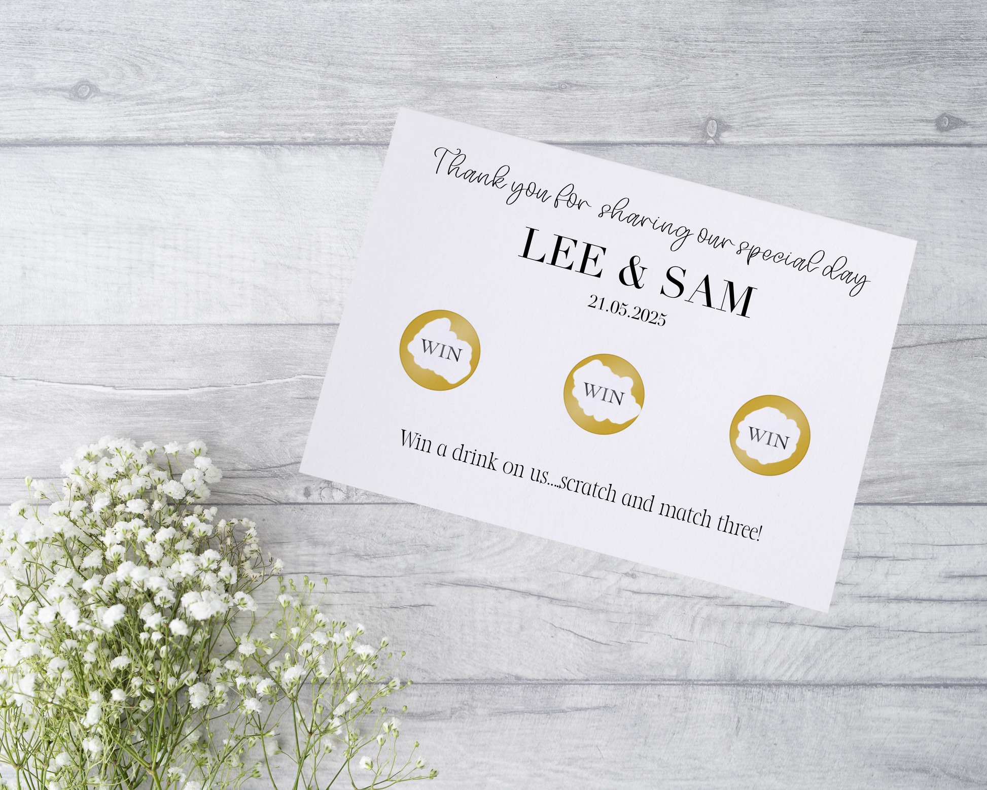  A close-up view of a beautifully designed scratch card with elegant typography and decorative elements. The scratch card features customised names and a wedding date, surrounded by symbols representing hidden prizes.