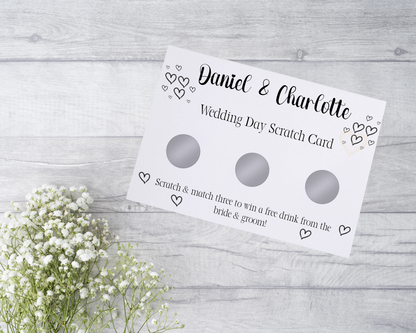  A close-up view of a beautifully designed scratch card with elegant typography and decorative elements. The scratch card features customised names and a wedding date, surrounded by symbols representing hidden prizes. The card is held by a hand, ready to be scratched off, adding an element of anticipation and excitement.