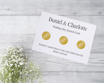  A close-up view of a beautifully designed scratch card with elegant typography and decorative elements. The scratch card features customised names and a wedding date, surrounded by symbols representing hidden prizes.