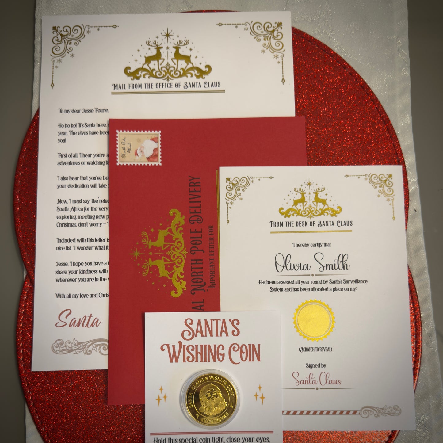 Set of Santa Claus-themed letters, envelope, and wishing coin on a red background
