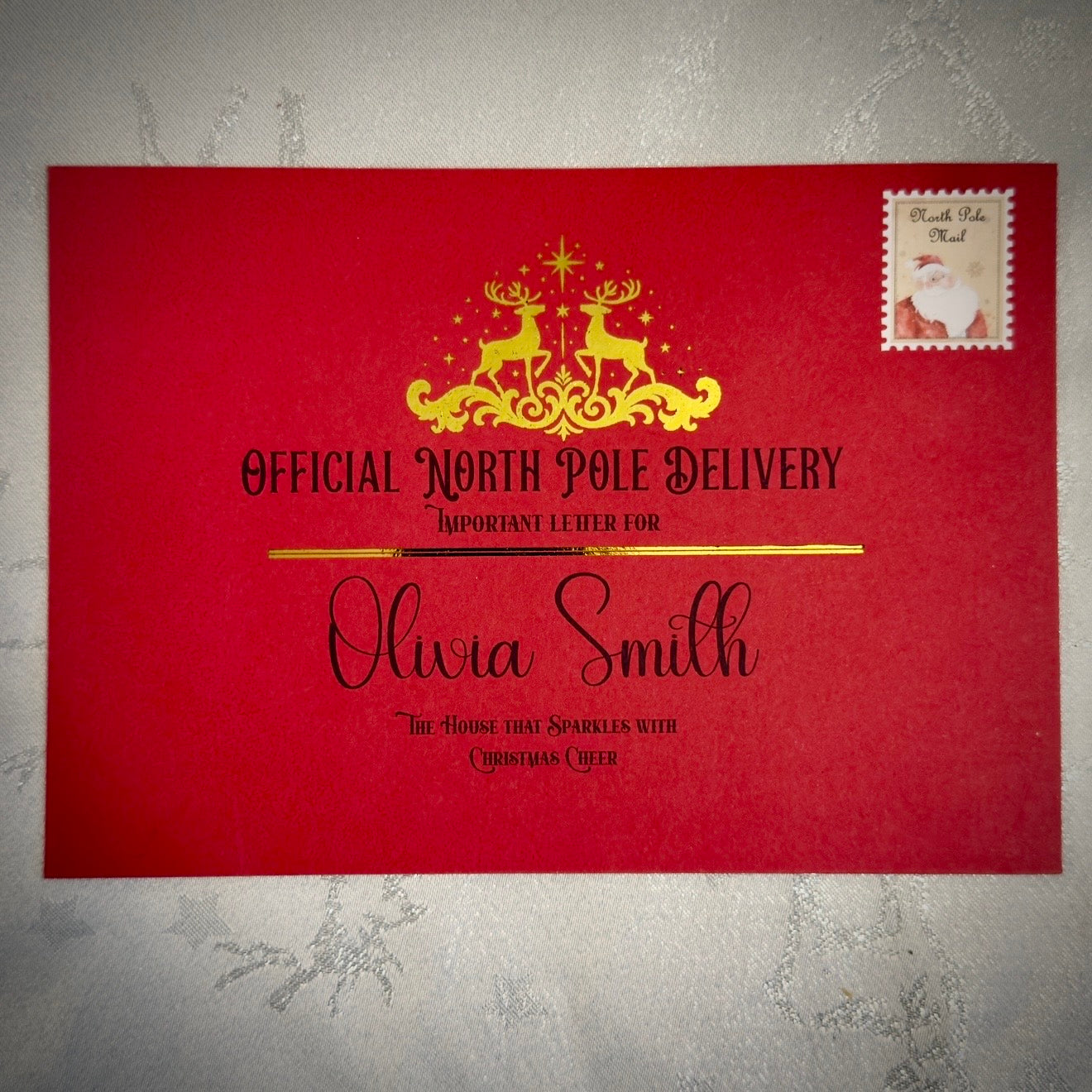 Red letter with gold text and Santa Claus stamp on a textured gray background