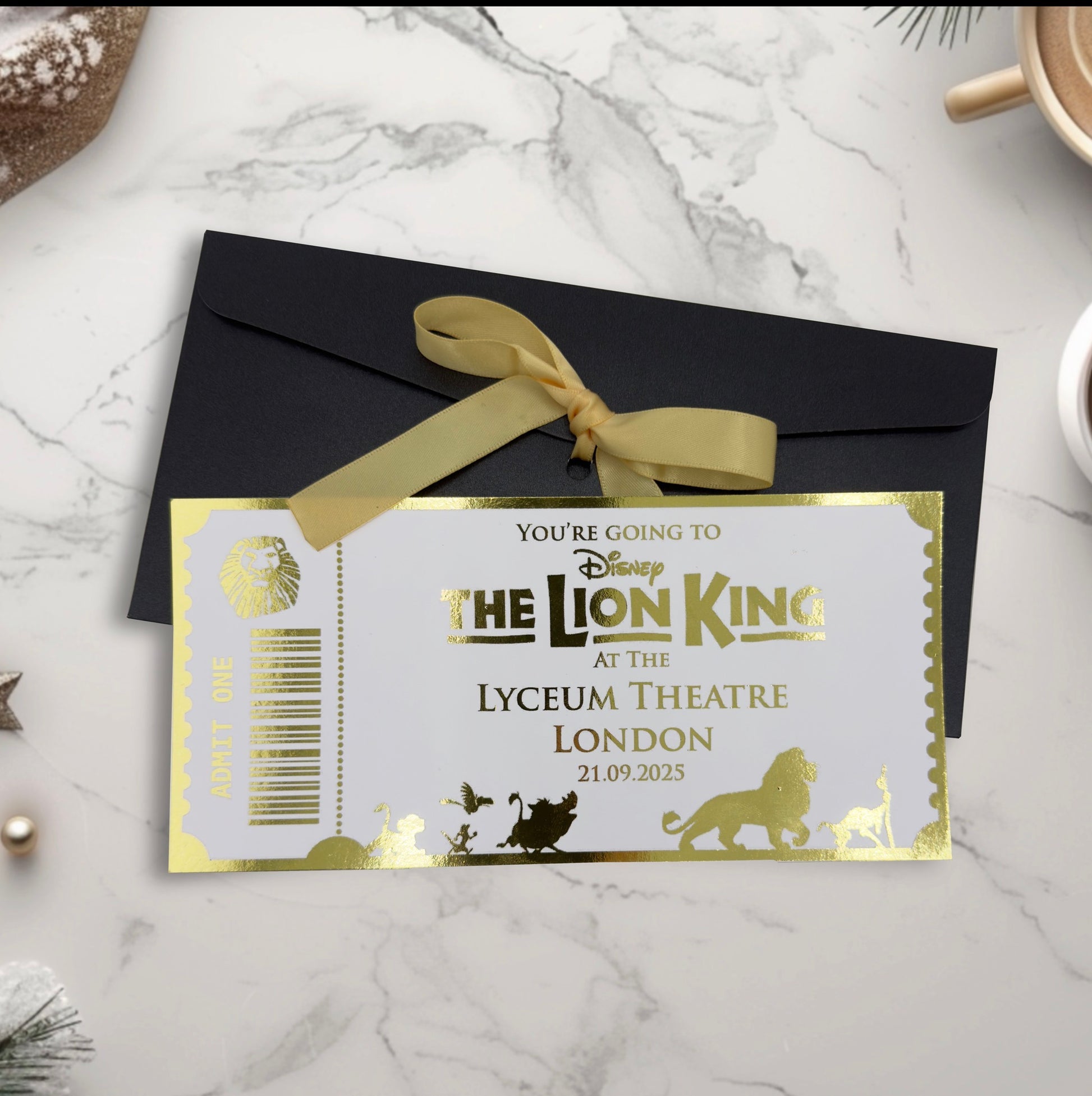 Invitation card for 'The Lion King' at the Lyceum Theatre London with a black envelope and gold ribbon.